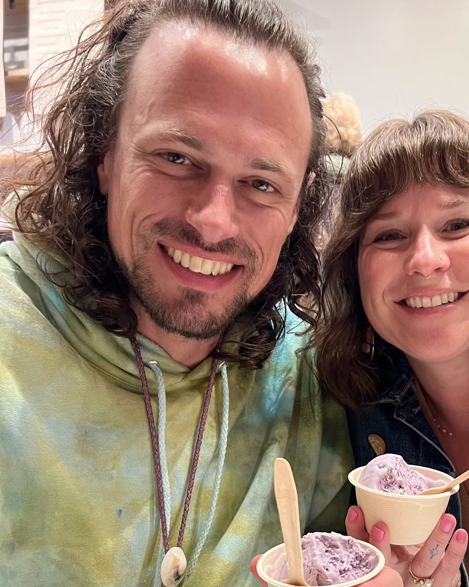 The same cowrie shell bolo tie worn casually over a tie-dye hoodie