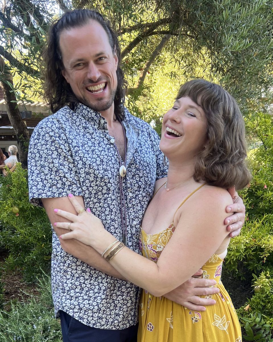 A Holo Holo Bolo cowrie shell bolo tie worn over a floral shirt at a garden wedding